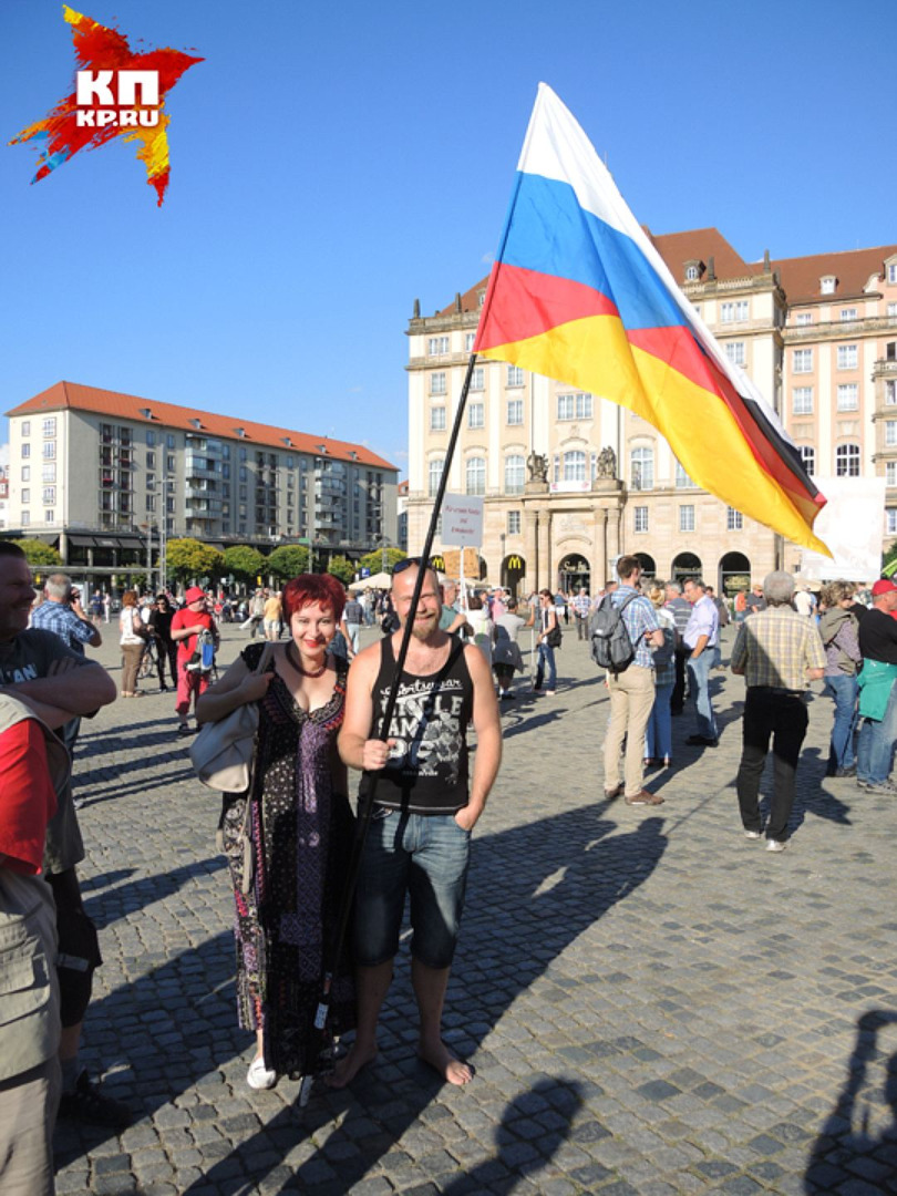 Дарья и немец держат флаг, наполовину немецкий, наполовину русский. Фото: Дарья АСЛАМОВА
