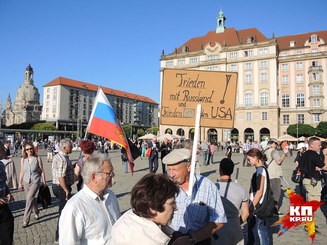Русский флаг и плакат "Дружба с Россией" на митинге в Дрездене. Фото: Дарья АСЛАМОВА