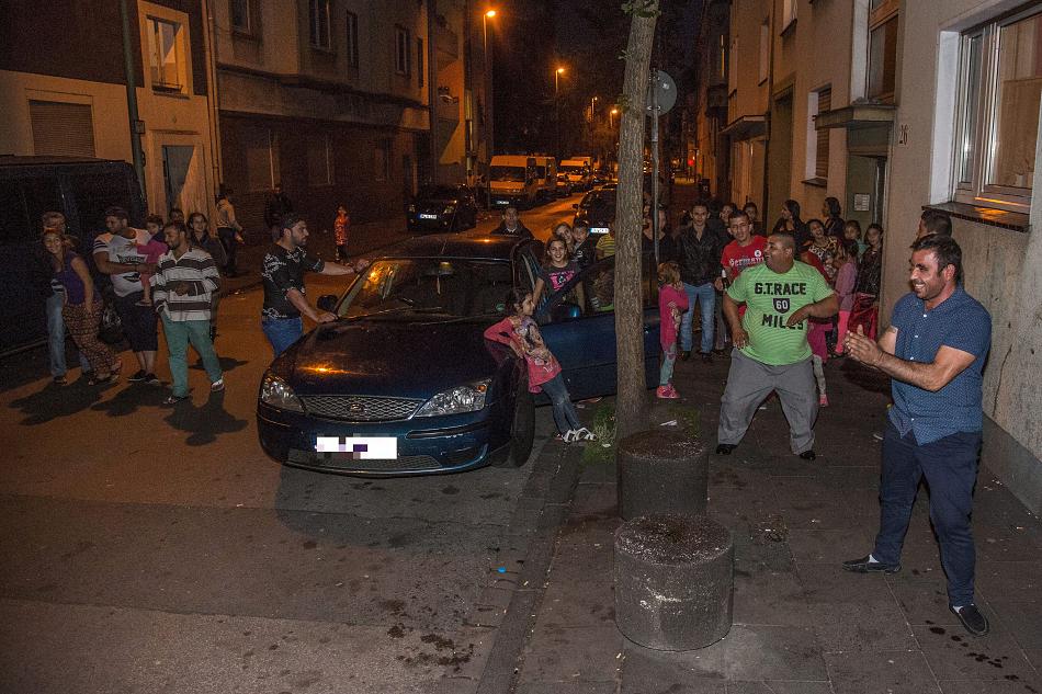 Ночью жители-румыны танцуют на улице, акустическая система в машине гремит громкой музыкой